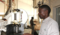 Obbey Moyani works the machinery during the production of the cans
